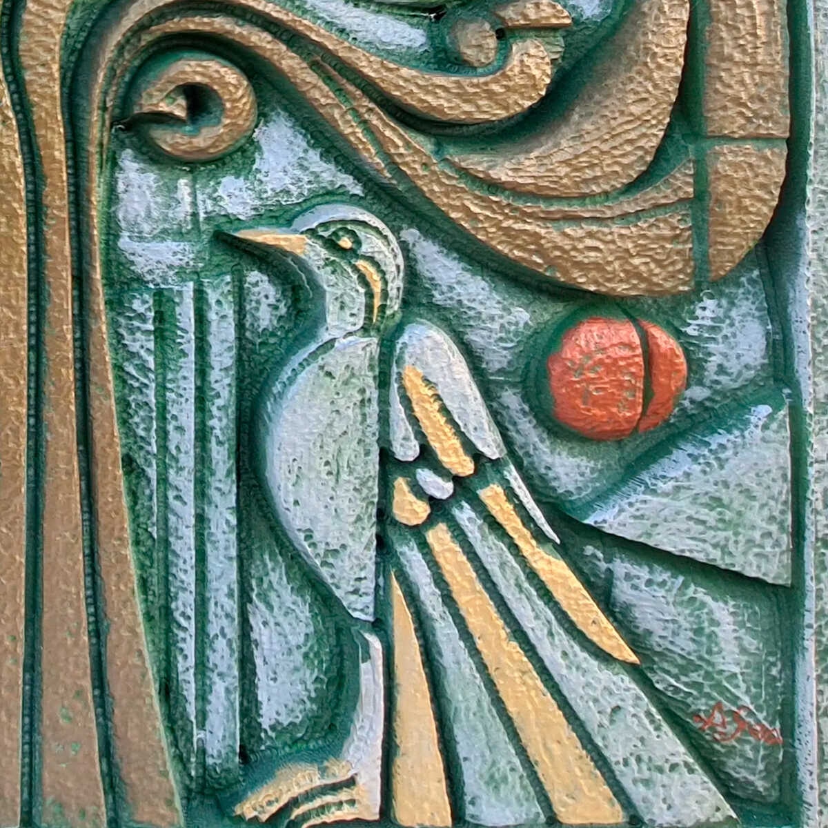 Un relieve tallado nos sorprende con un pájaro, amarillo y blanco, de formas casi soñadas. Está erguido junto al texto:
